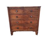 A George IV mahogany chest of drawers with projecting rounded ribbed column corners, the two short