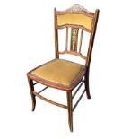 An Edwardian inlaid chair, the shaped back with brass studded upholstered panel above a rosewood