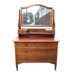 An Edwardian mahogany dressing table inlaid with chequered banding, the arched bevelled mirror above
