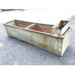 A rectangular galvanised trough with tubular rim, having box to end with valve ballcock for water