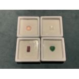 Four individually boxed semi-precious stones - a round rose quartz, a square-cut rainbow