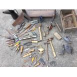 Miscellaneous tools including a cobblers last, spanners, chisels, an oil can, an axe, a flat iron,