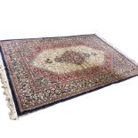 An Indian oriental rug woven with a hexagonal ivory floral field framing a scalloped shaped
