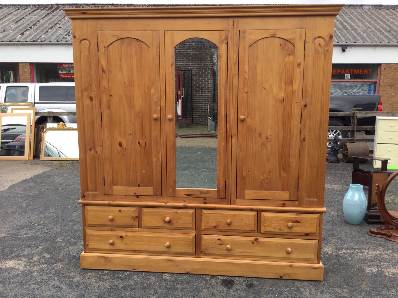 A large pine wardrobe with moulded cornice above three arched doors - the central one with - Image 2 of 3