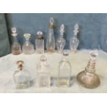 A collection of decanters & stoppers including some with hallmarked silver mounts, engraved, a