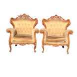 A pair of Louis VI style armchairs with pierced scroll carved backs above button upholstered panels,