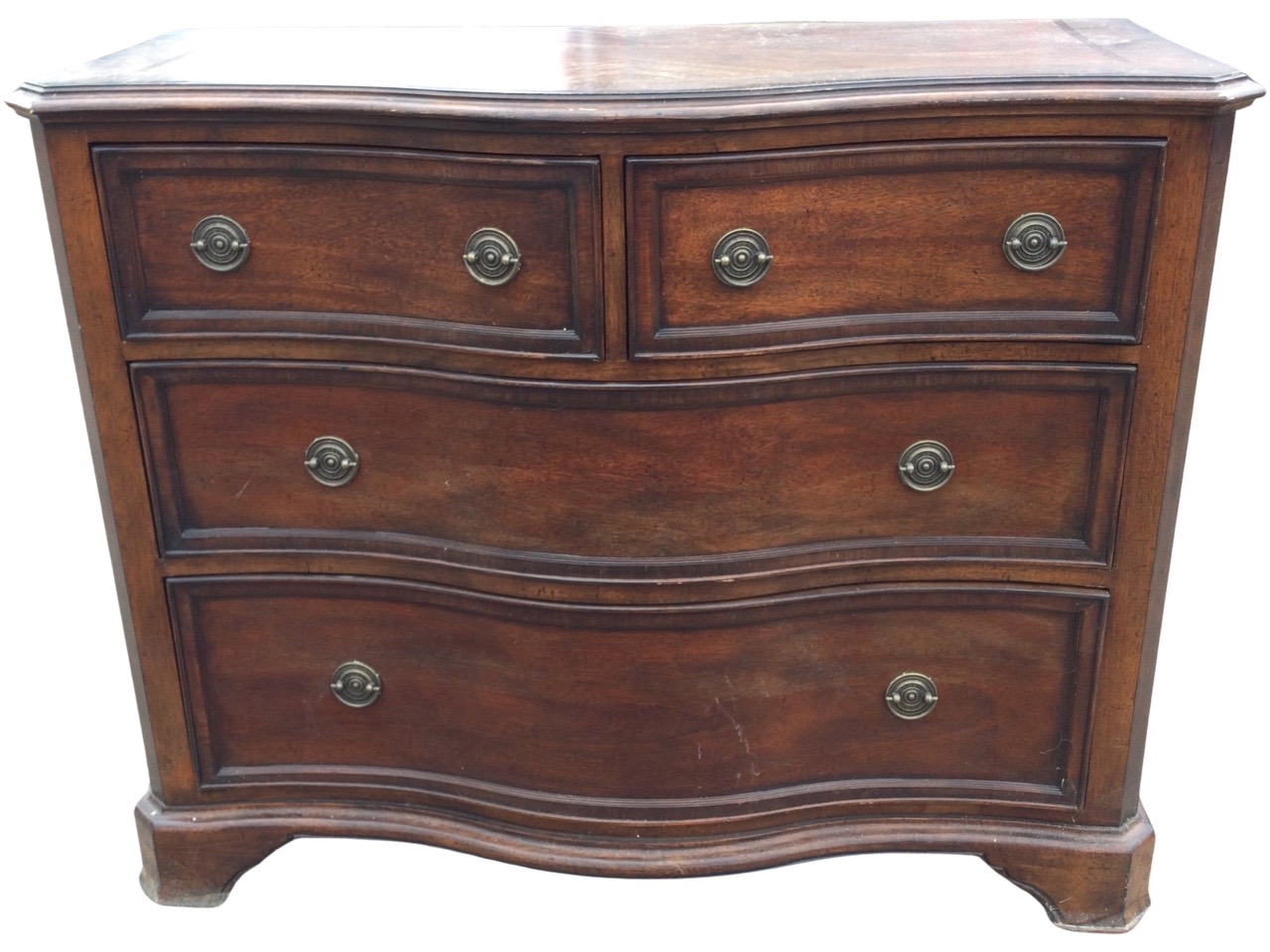 A Georgian style serpentine shaped chest by Willis & Gambier, the canted crossbanded top above two