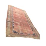 An antique Belouchi runner woven with madder field of paisley motifs within a serrated blue