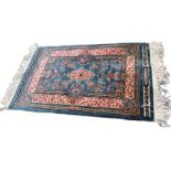 A Chinese handwoven silk rug/wall hanging of traditional design with blue floral field framed by
