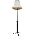 A painted art nouveau standard lamp with column on wrought iron scrolled base applied with