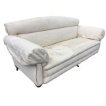 A three-seater Victorian sofa with arched padded back above a sprung upholstered seat, raised on