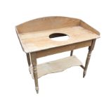 A Victorian pine washstand with shaped back above rectangular top pierced for bowl, raised on turned