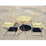 A garden table & chair set with two folding chairs having pierced scrolled wrought iron decoration