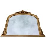 A Victorian style gilt overmantle mirror with arch shaped plate in moulded frame surmounted by a