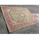 An oriental style rug woven with olive green floral field centered by diamond shaped medallion,