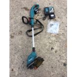 A Makita electric garden strimmer with battery charging pack, sling, mains cable, etc.