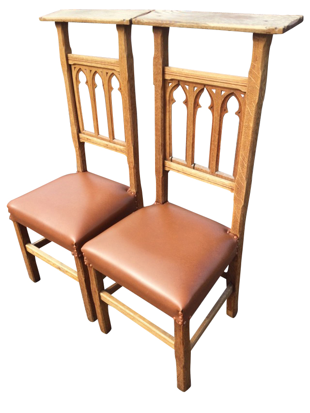 A pair of high-back oak prie-dieu chairs with chiselled platform back rails above gothic fretwork