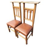 A pair of high-back oak prie-dieu chairs with chiselled platform back rails above gothic fretwork
