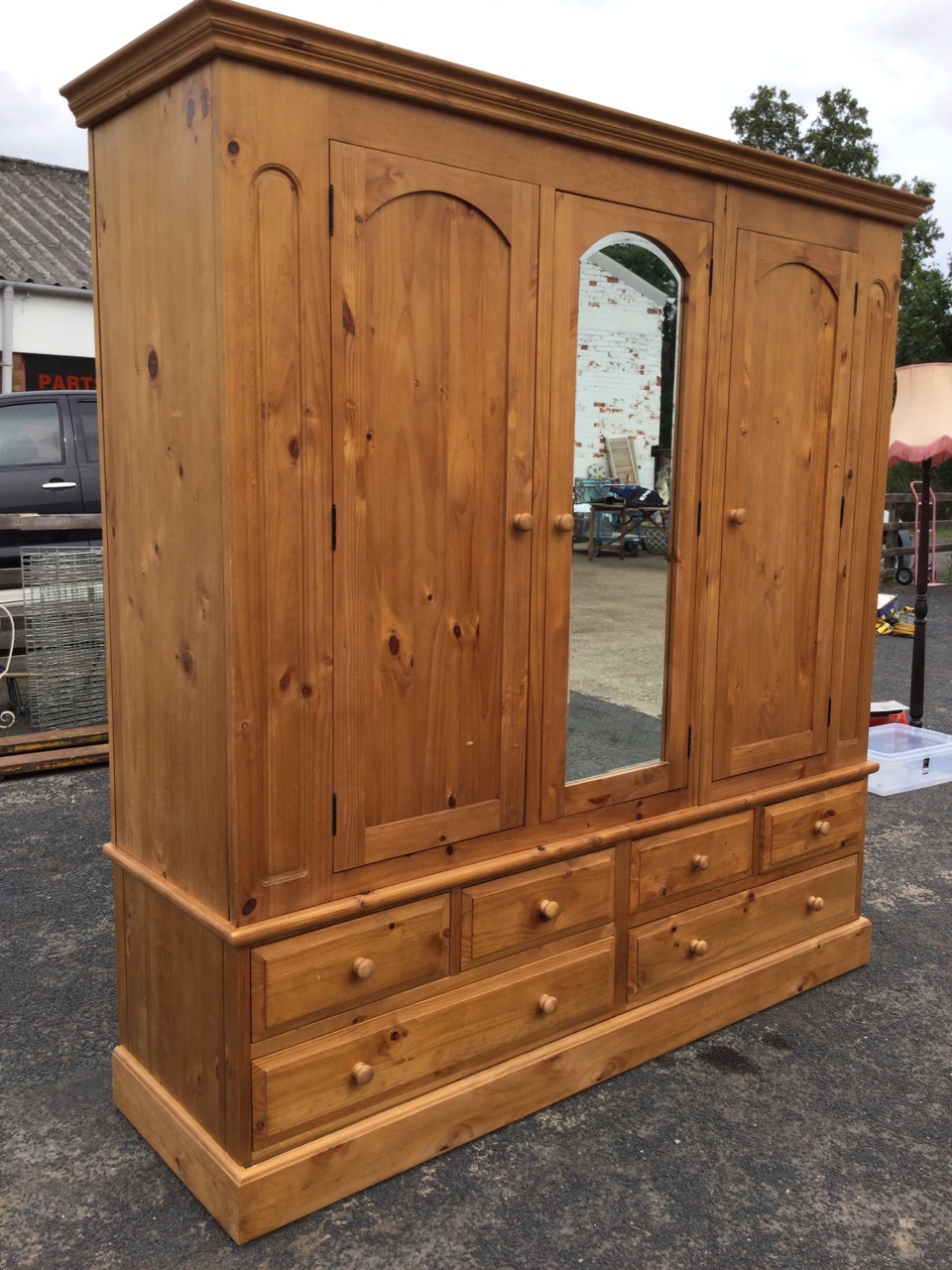 A large pine wardrobe with moulded cornice above three arched doors - the central one with - Image 3 of 3