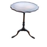 A circular mahogany occasional table, the scalloped moulded tray top supported on a slender turned