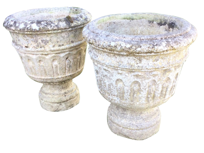 A pair of composition stone urns with moulded rims above tapering fluted bucket shaped pots,