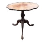 A circular mahogany occasional table, the scalloped tray top revolving on a gadrooned carved