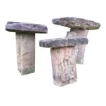 A graduated set of three roughly hewn garden staddle type stones, with sandstone slabs on