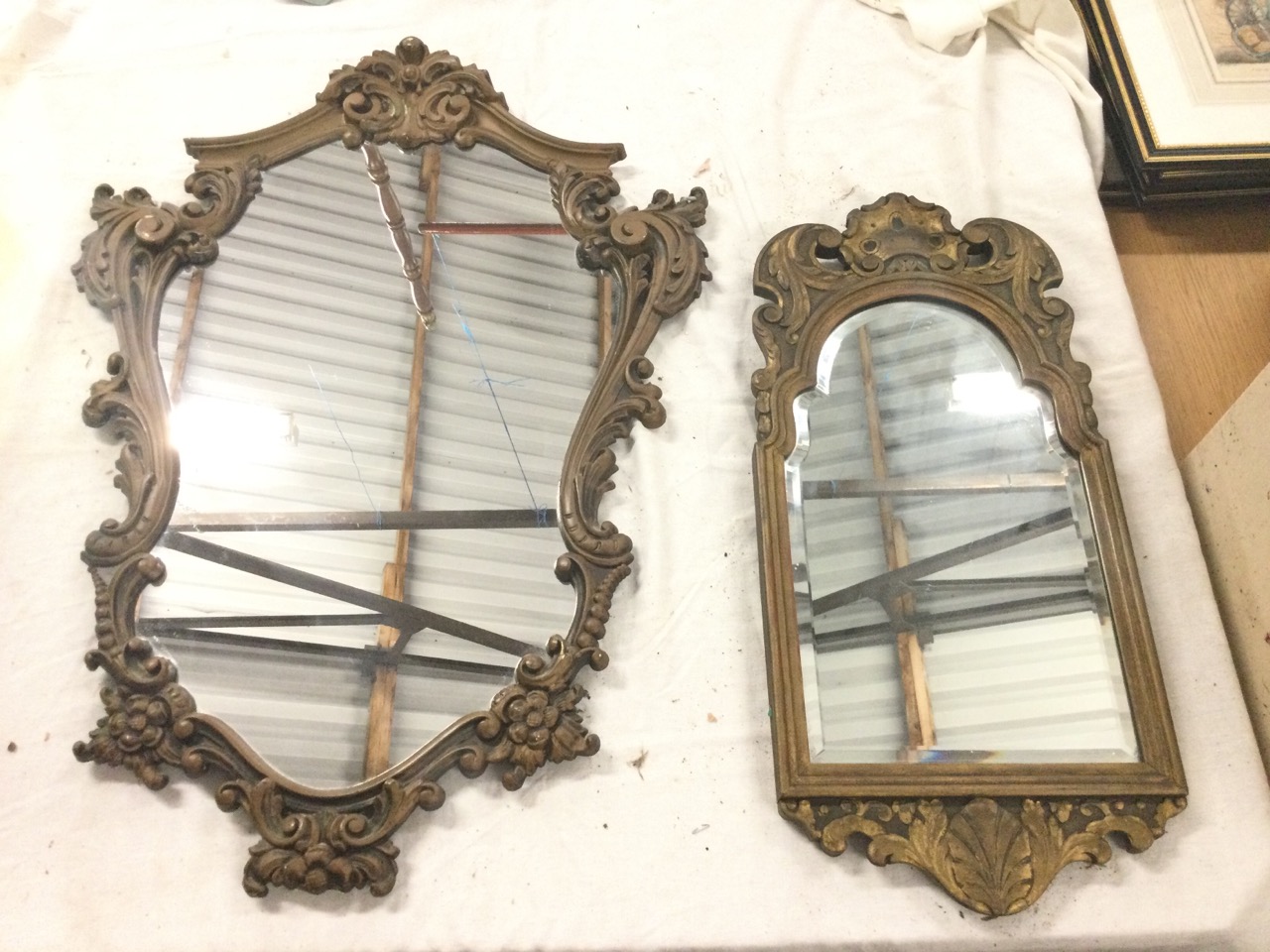 A carved wood framed mirror with arched bevelled plate surmounted by pierced leaf scrolls framing