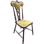 An art nouveau mahogany chair with padded back above a pierced fretwork cut splat framed by turned