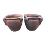 A pair of terracotta salt glazed pots, each moulded with four tapering fluted handles. (11.75in x