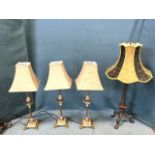 A set of three tablelamps with gilded ribbed palm-tree type columns on square bases with scrolled