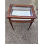 A rectangular mahogany bijouterie table with moulded hinged lid to glass framed compartment,