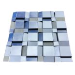 A square decorative modern mirror, with tile sized bevelled plates set at various angles, with