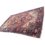 An antique Anatolian carpet woven with central blue floral medallion with pendants on busy madder