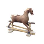 An Edwardian upholstered childs rocking horse, the carved body in stripped down padded form, on