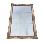 A large rectangular mirror in painted cushion moulded frame, with foliate scrolled gilt & gesso