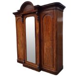 A Victorian mahogany breakfront wardrobe, the central section with arched moulded cornice above a