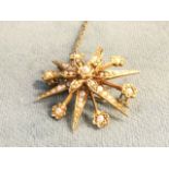 A 9ct hallmarked gold star brooch set with seed pearls, having hinged pin to verso with safety chain