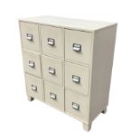 A modern painted cabinet of nine drawers mounted with cup label-holder handles. (33in x 15.5in x