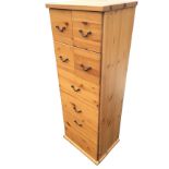 A pine tower cabinet of drawers with four small drawers above a pair of larger drawers, and a bottom