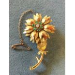 An 18ct gold emerald & diamond brooch modelled as a tropical flower, with leaves framing six claw-