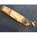 An Edwardian leather golf bag containing eight hickory shafted golf clubs including three wood-