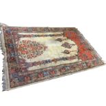 An eastern style prayer rug woven as an interior with two decorative pillars framing a vase of