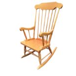 A contemporary rocking chair with spindleback and shaped arms on ring-turned supports, raised on