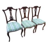 A pair of late Victorian mahogany salon chairs with scroll carved back rails centering on shells