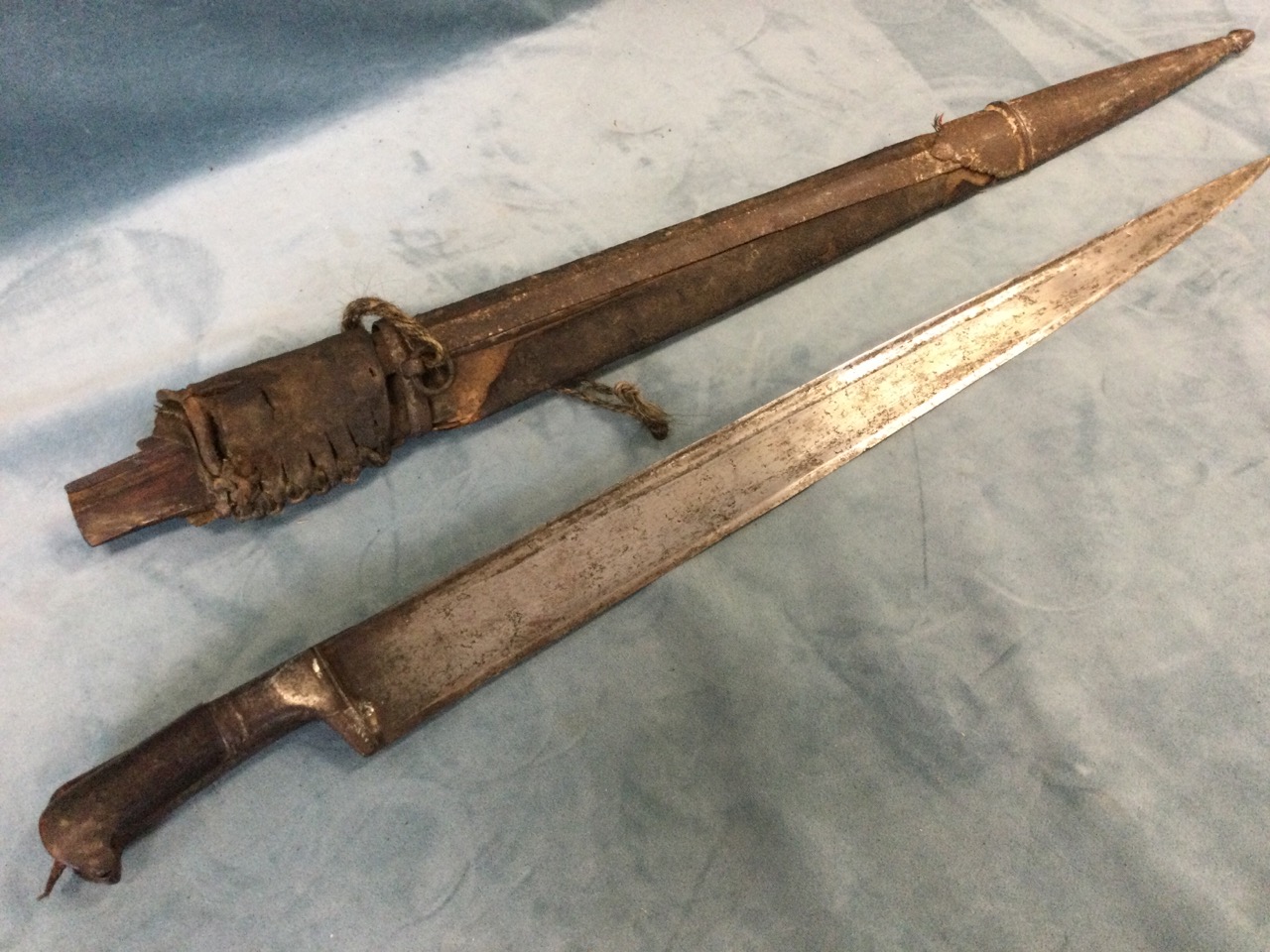 A nineteenth century sword with tapering steel blade having horn handle, the wood scabbard with iron