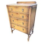 A George VI oak chest of drawers with beaded upstand to rectangular moulded top, above four long