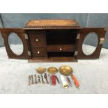 An oak smokers cabinet, the hinged top with beaded tray above oval glazed doors with bevelled