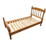 A pine single bed with turned spindles to headboard and tailboard, the baluster cornerposts with