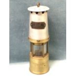 A miners lamp by JH Naylor Ltd of Wigan with tapering aluminium chimney above glass & brass